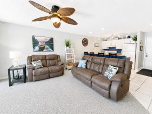 a living room with two couches and a ceiling fan at Serenity Pointe Boat Slip in Osage Beach +35 photos