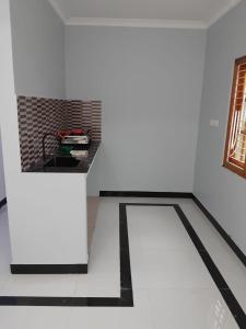 a white room with a black counter and a table at CaReville Chunnakam in Chunnakam