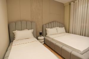 two beds in a small room with white sheets at Blue Coast-Vala Mar Villa in Hamallë