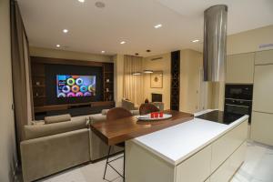 a kitchen and living room with a couch and a tv at Blue Coast-Vala Mar Villa in Hamallë