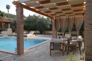 a patio with a pergola and a swimming pool at Gravanis Resort in Sikáminon