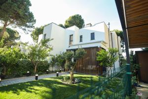 a white house with a tree in the yard at Blue Coast-Vala Mar Villa in Hamallë