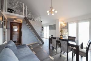 a living room with a dining table and a staircase at Apartmani Novia in Bibinje