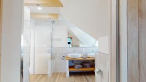 a bathroom with two sinks and a staircase at Penthaus Aldebaran by Salzkammergood Living in Tauplitz +12 photos
