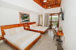 a bedroom with two beds and a table and a desk at El Barranco Galapagos in Puerto Ayora +97 photos