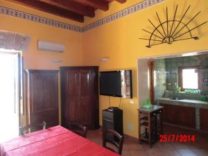 a dining room with a table and a television in a room at Holiday home Santa Flavia in Santa Flavia