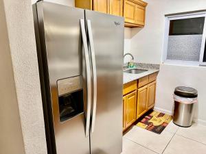 a stainless steel refrigerator in a kitchen with wooden cabinets at Anna's Joye Chatham in Montego Bay