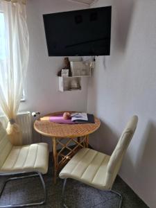 a room with a table and two chairs and a tv at Ferienweingut Schäfer in Niedersteinbach