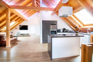 an open kitchen and living room with wooden ceilings at Ferienwohnung Bergele in Rot an der Rot