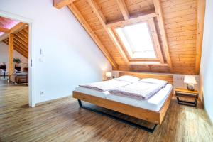 a bed in a room with a wooden ceiling at Ferienwohnung Bergele in Rot an der Rot