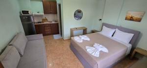 a small bedroom with a bed and a kitchen at Bayside Apartments in Vasiliki