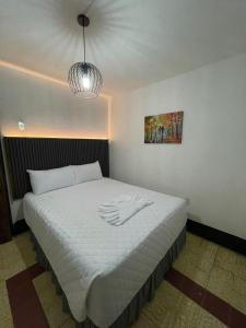 a bedroom with a large bed with a white blanket at Hotel & Restaurante Teresàs Bistro in Antigua Guatemala