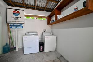 a laundry room with two washing machines and a sign at Blue Horizon Studios in Roatán