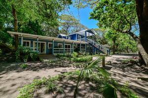 a blue house in the middle of trees at Blue Horizon Studios in Roatán