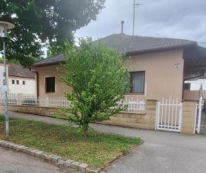 a house with a fence and a tree in front of it at Ferienwohnung Anita in Rust