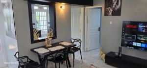 a dining room with a table and chairs and a television at The Amanda Bed & Breakfast in Migori +2 photos