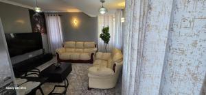 a living room with two chairs and a flat screen tv at The Amanda Bed & Breakfast in Migori