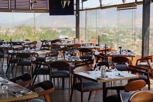 a restaurant with tables and chairs with a view at Hotel Fortin Plaza in Oaxaca City