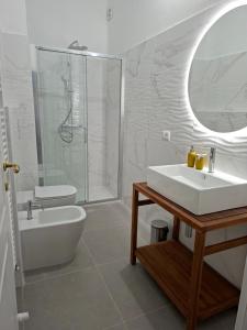 a white bathroom with a sink and a shower at Dimora Tre Marie in LʼAquila