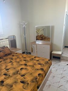 a bedroom with a large bed and a dresser at Modern studio apartment in Mogadishu