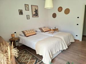 a bedroom with a white bed with a table on it at Casa Ewa in Fiavè