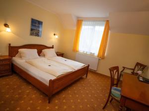 a bedroom with a bed and a desk and a window at Restaurant Gästehaus Seiger in Sankt Lorenzen bei Knittelfeld +39 photos