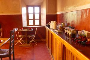 a kitchen with a counter and a table and a window at KASBAH ALTAÏR in El Kelaa des Mgouna