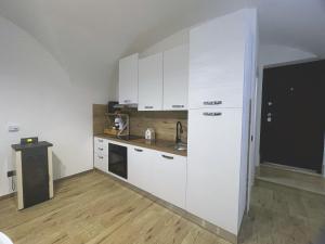a kitchen with white cabinets and a wooden floor at La Casa di Lu & Li in Subiaco