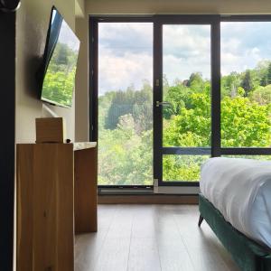 a bedroom with a bed and a large window at Celest Boutique Urban Hideaway in Braşov