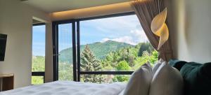 a bedroom with a bed and a large window at Celest Boutique Urban Hideaway in Braşov