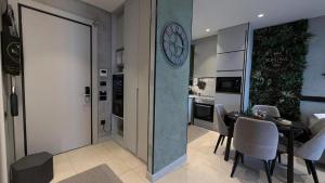 a kitchen and dining room with a clock on the wall at KRUNA 406 Luxury Sea View Apartment with Parking, Minibar, Spa & Beach - Includes 2 Complimentary Non-Alcoholic Beach Drinks & Welcome Gift in Budva +43 photos