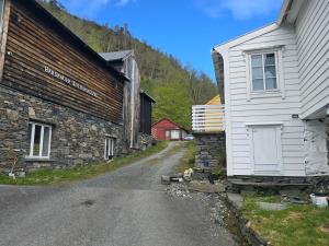ein Feldweg neben einem Gebäude und einem Haus in der Unterkunft Gamlastova in Samlanes