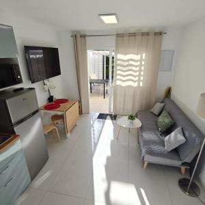 a living room with a couch and a table at Bungalow Gran Canaria Oasis in Maspalomas