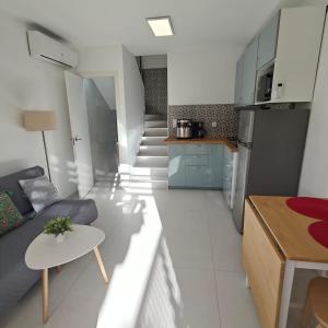 a kitchen and a living room with a couch and a table at Bungalow Gran Canaria Oasis in Maspalomas