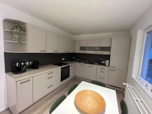 a kitchen with white cabinets and a table and a window at Work & Stay - Monteurzimmer - FeWo am NOK in Rendsburg