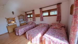 a bedroom with three beds and a window at Chalet Pico Frentes in Cidones