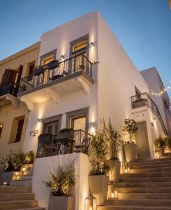 a white building with stairs and potted plants at TOP SUITES in Ermoupoli