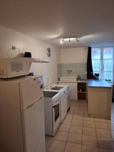 a kitchen with a white refrigerator and a stove top oven at Gite saint marc in Mer