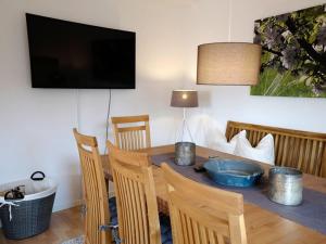 a dining room with a table with chairs and a television at Apfelblüte - Ferienhaus - ABC321 in Klein Warin