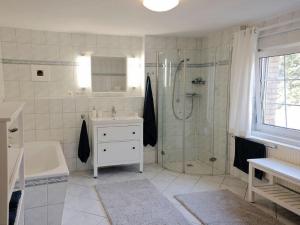 a bathroom with a shower and a sink and a tub at Apfelblüte - Ferienhaus - ABC321 in Klein Warin +16 photos