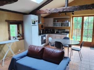 a living room with a couch and a table at La Bouvardière, gîte au calme, en pleine campagne, tout près de Rennes in Le Rheu