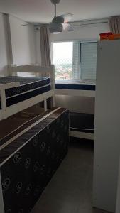 a room with two bunk beds and a window at Apto 83 in Itanhaém