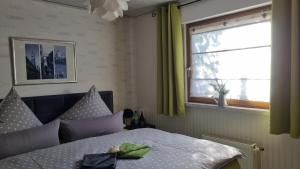 a bedroom with a bed and a window with green curtains at Ferienwohnung Sonnenblick in Bischofswerda