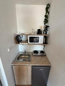 a small kitchen with a microwave and a sink at Serenity Hill-Bulharsko U Nás in Sveti Vlas