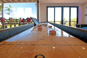 a long wooden table in a room with windows at 20-30 Knots- 5BR4BA Game Night Villa Hot Tub in El Sargento +72 photos