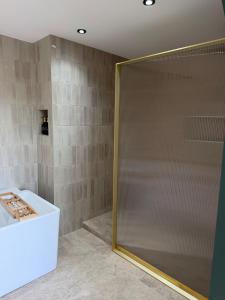 a shower with a glass door in a bathroom at Le Nid du Cortil in Theux