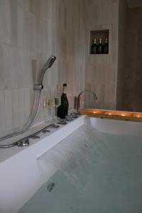 a bath tub with two faucets in a bathroom at Le Nid du Cortil in Theux +22 photos
