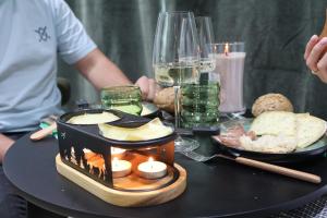 a table with a plate of food and glasses of wine at Le Nid du Cortil in Theux