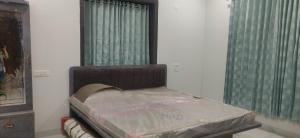a bed in the corner of a room with two windows at Orchard Suite in VÄngaon