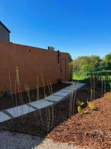 a garden with a fence and a walkway at Le Nid du Cortil in Theux